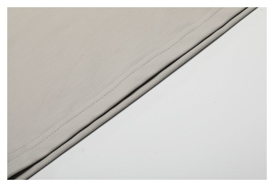 Close-up of the double-stitched bottom hem of a light gray T-shirt.
