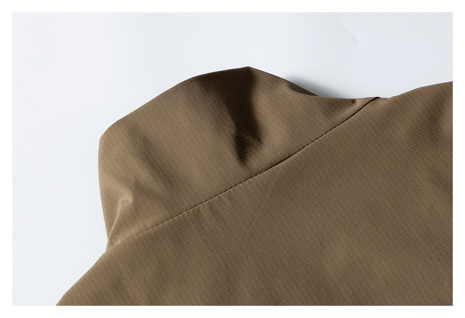 Close-up of the brown jacket's collar and shoulder seam against a white background.