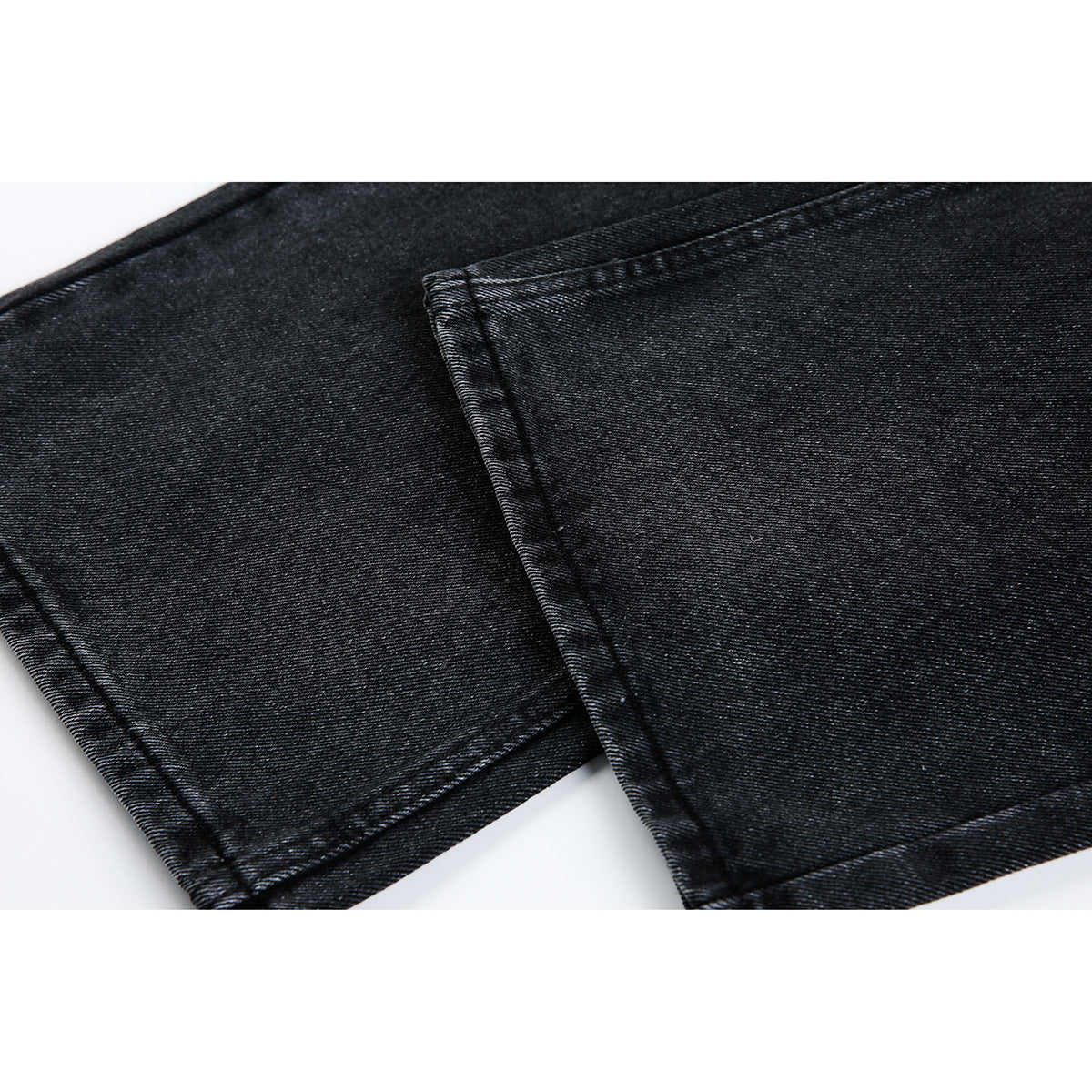 Close-up of dark denim jeans showing the leg fabric, side seam, and stitched hem.