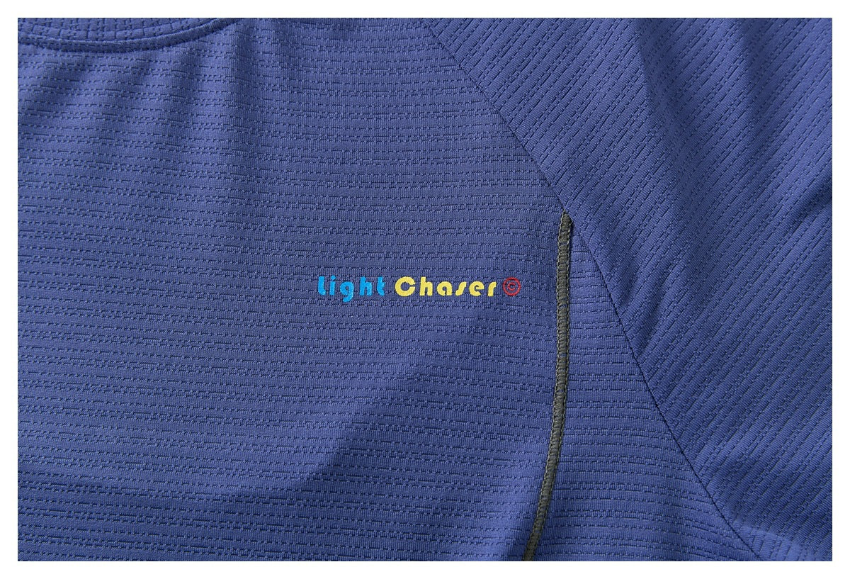 Close-up of a blue textured shirt with a small multicolored “Light Chaser” logo on the chest.