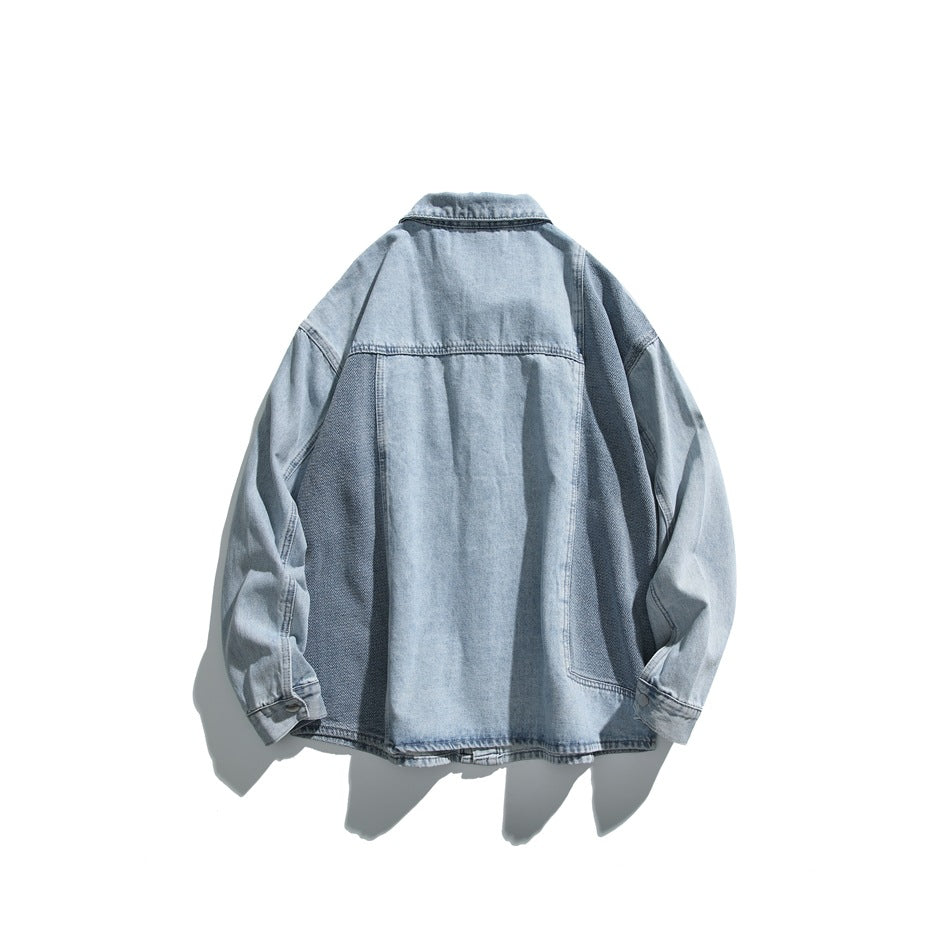Back view of a light blue denim shirt jacket laid flat, with darker textured side panels and sleeves.