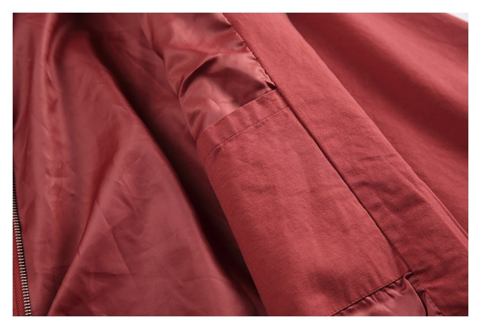 Close-up inside the brick-red jacket, showing the lining and a stitched seam.