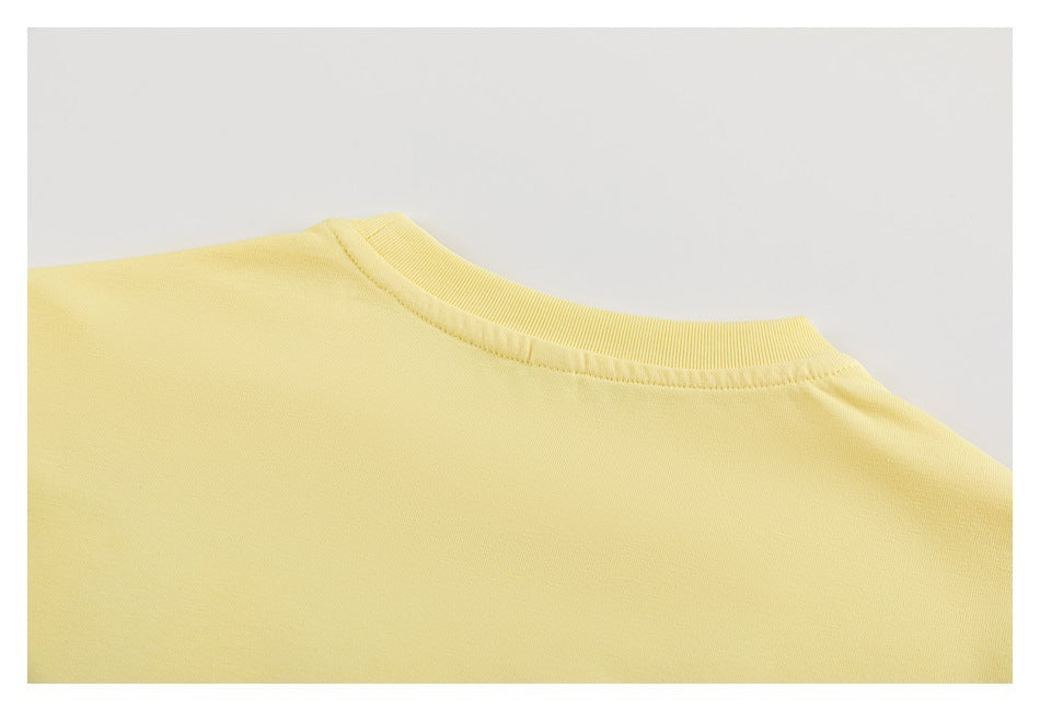 Close-up of the plain back neckline and shoulder area of the pale yellow T-shirt.