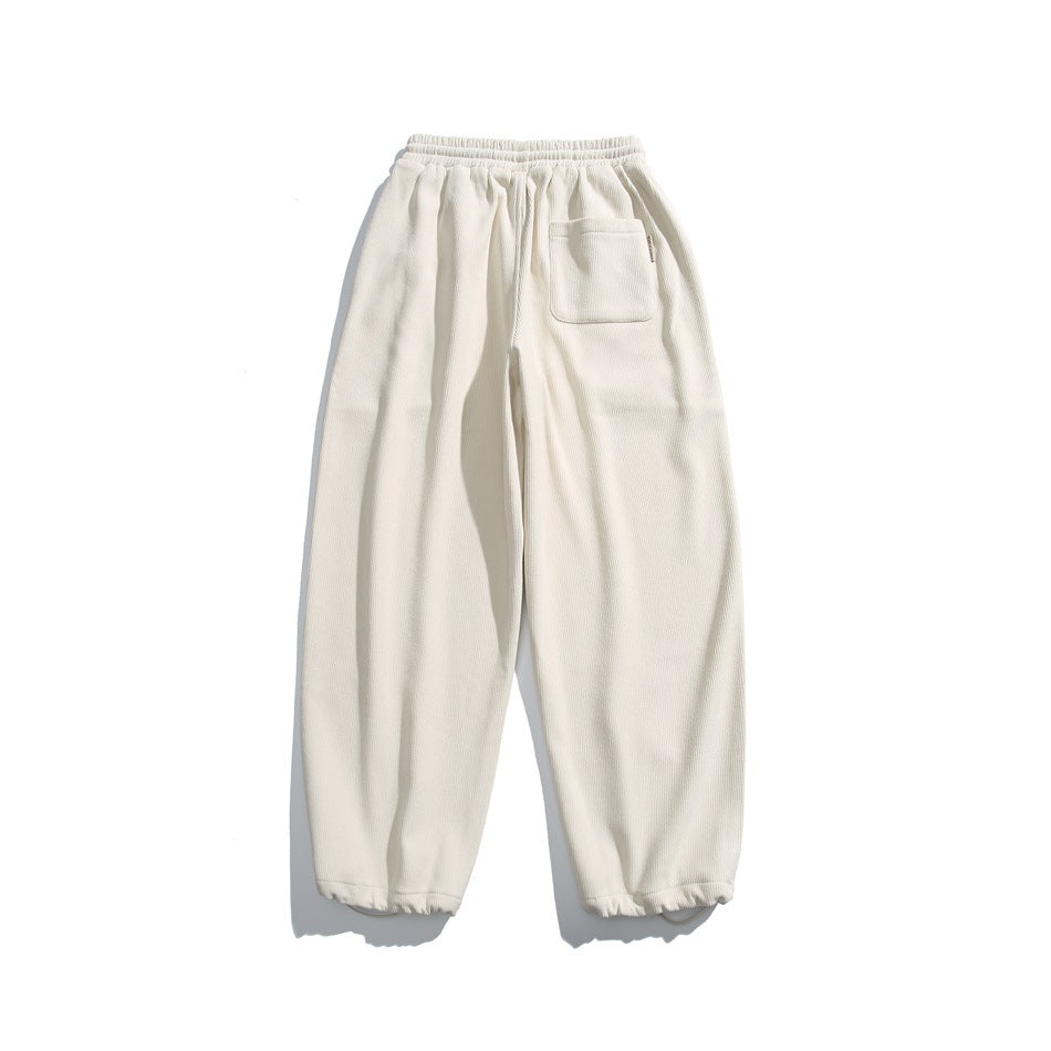 Back view of cream jogger pants with an elastic waist, a single patch pocket, and elastic cuffs.