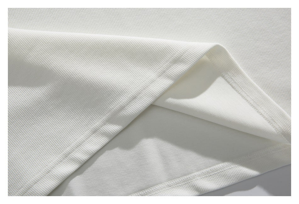 Close-up of the white top's folded hem showing the inside fabric and stitching.