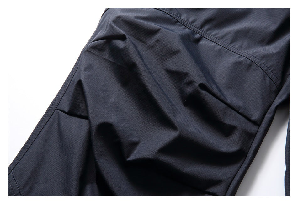 Close-up of dark navy trouser fabric with curved stitching and a subtle grid texture.