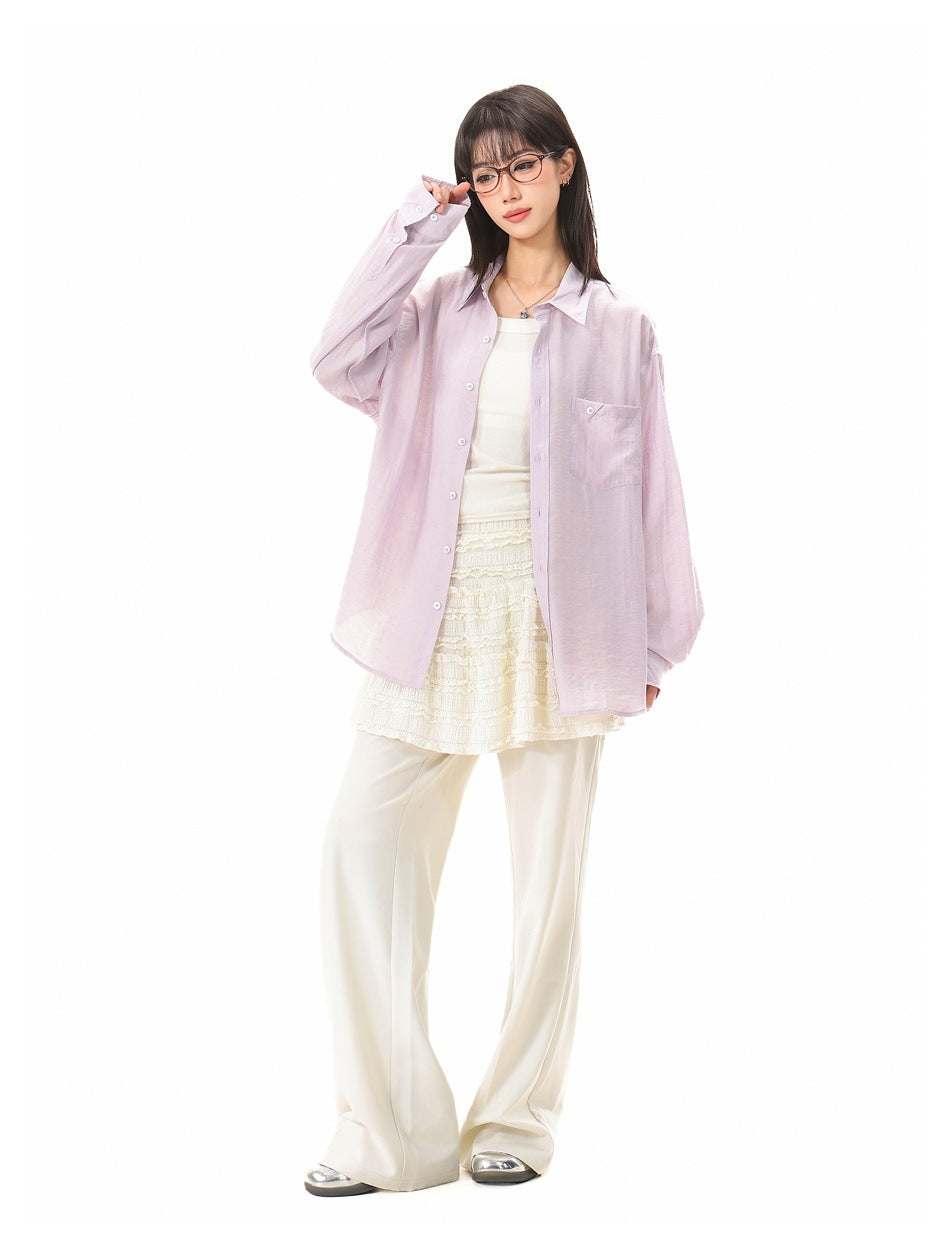 Model wearing an oversized pale lavender button-up shirt with a chest pocket over a white top and cream skirt.