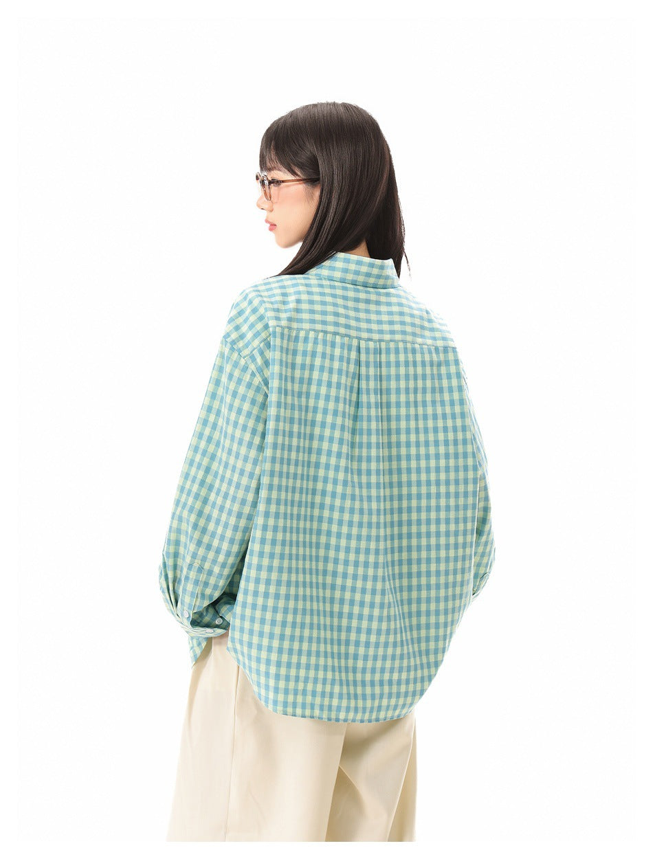 Rear three-quarter view of a model wearing a teal and pale yellow gingham shirt with a gathered back yoke.