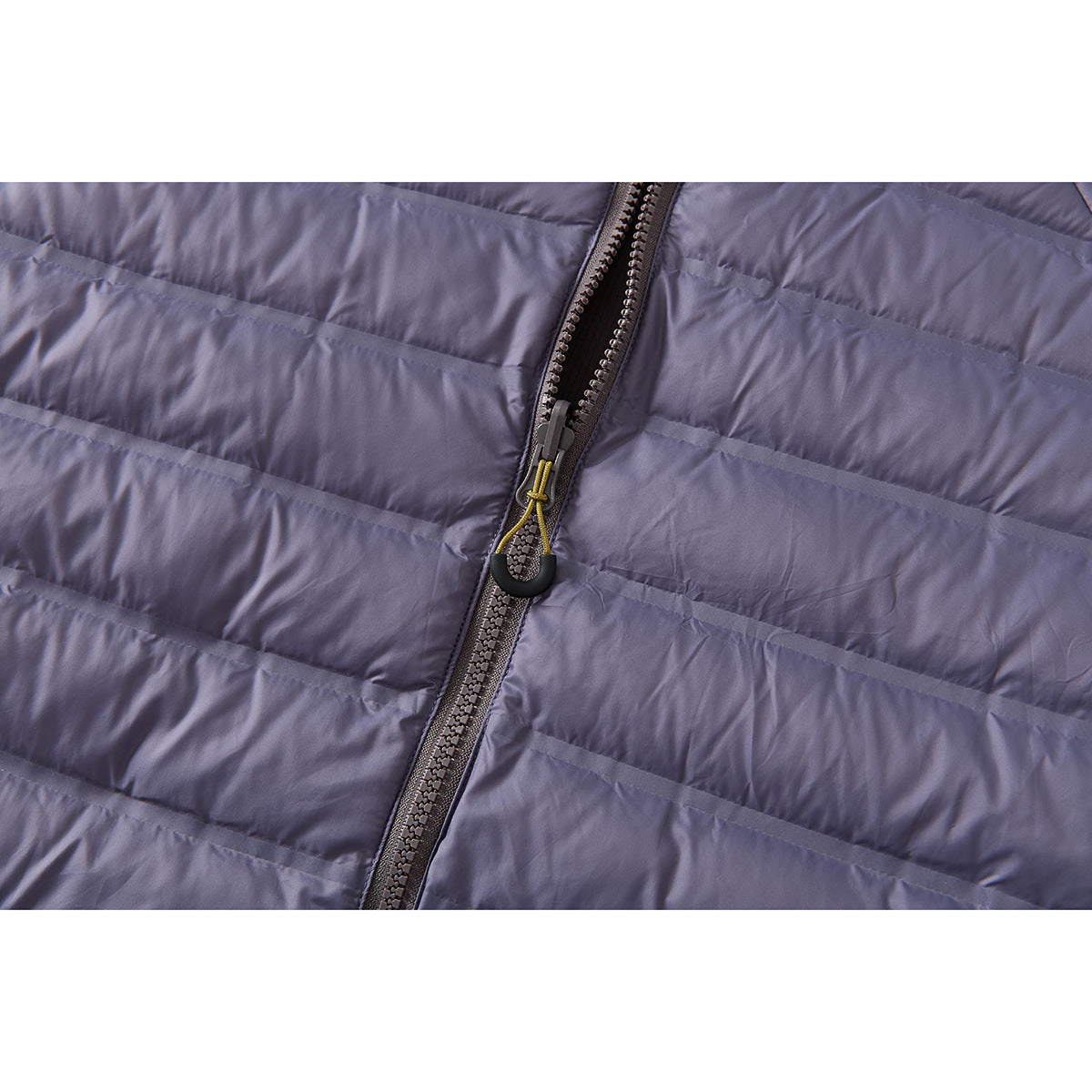 Close-up of the lavender-gray jacket's quilted front and zipper with a yellow cord pull.