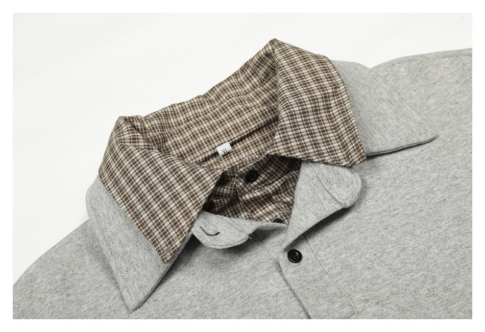 Close-up of the gray pullover's collar, button placket, and checked shirt collar and lining.