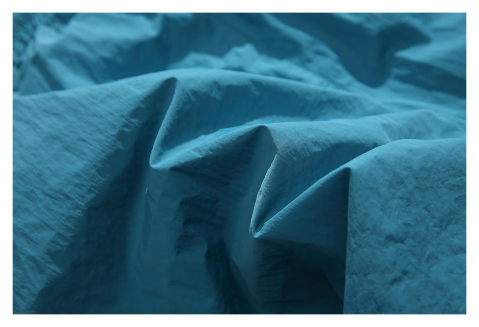 Macro view of the teal shorts’ crinkled fabric texture.