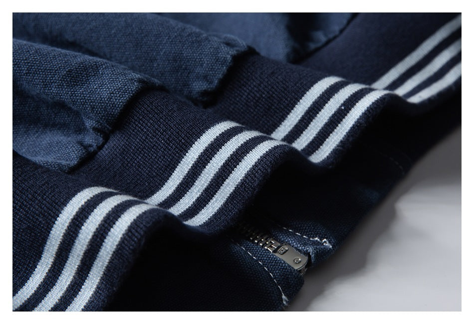 Close-up of a navy garment with white striped ribbed trim and a small zipper.
