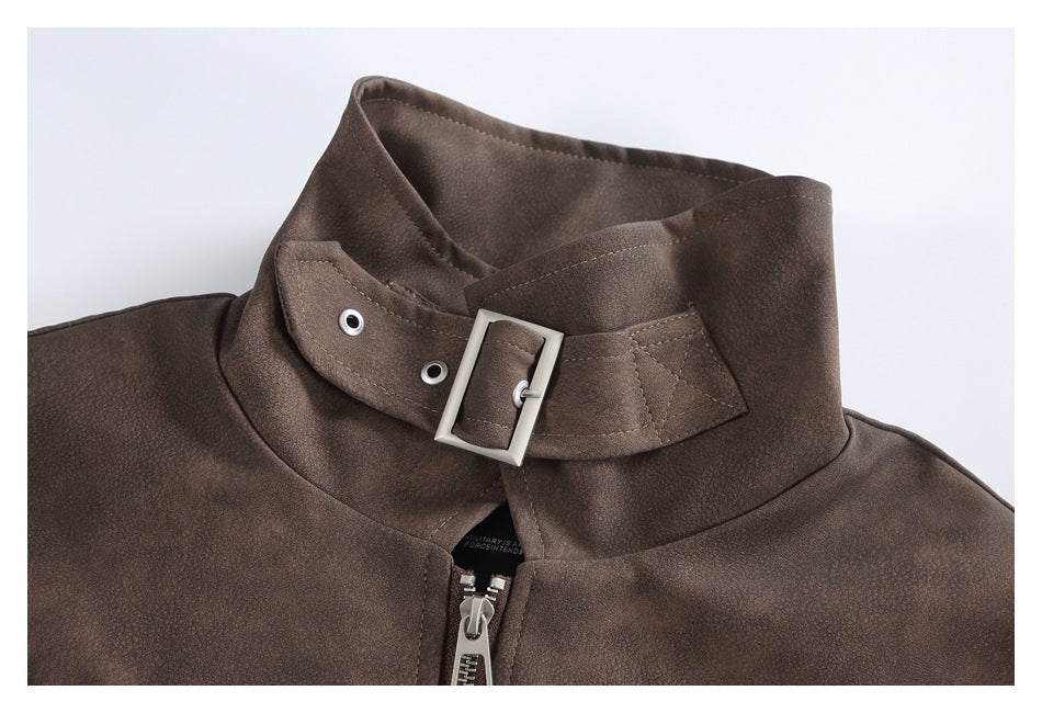 Close-up of a brown jacket’s stand collar with a buckle strap, metal eyelets and center zipper.