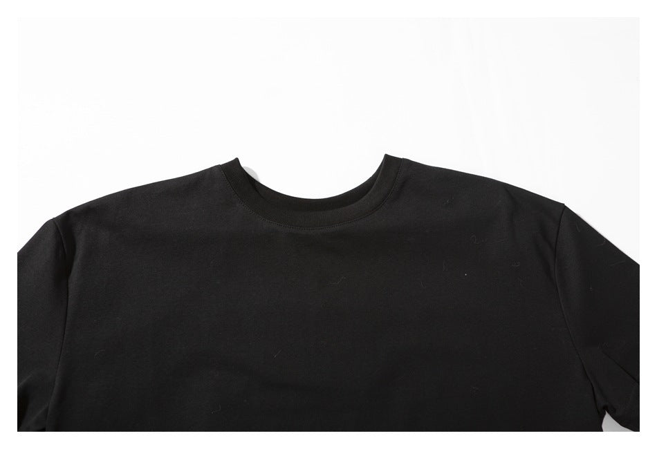 Close-up of the upper front of a plain black T-shirt, showing its crew neckline and shoulders.