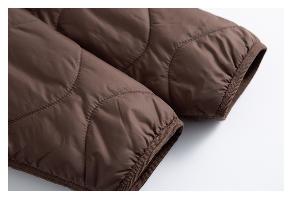 Close-up of two brown quilted jacket cuffs with patterned binding.