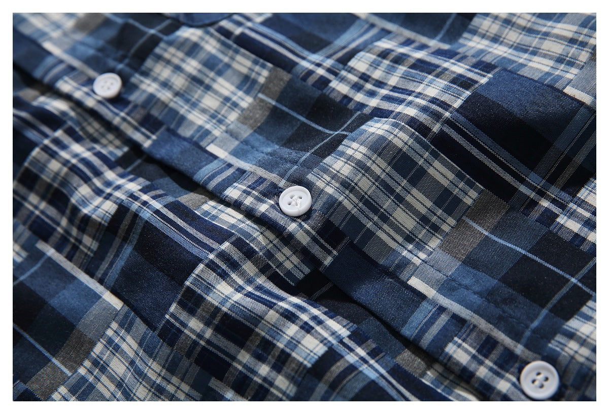 Close-up of a navy plaid shirt's button placket with white buttons.