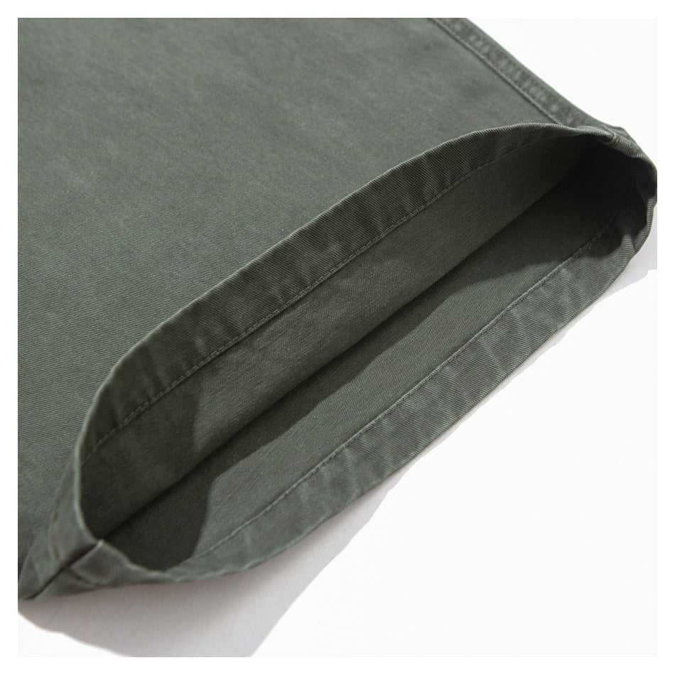 Close-up of the stitched hem opening on olive-gray trousers.