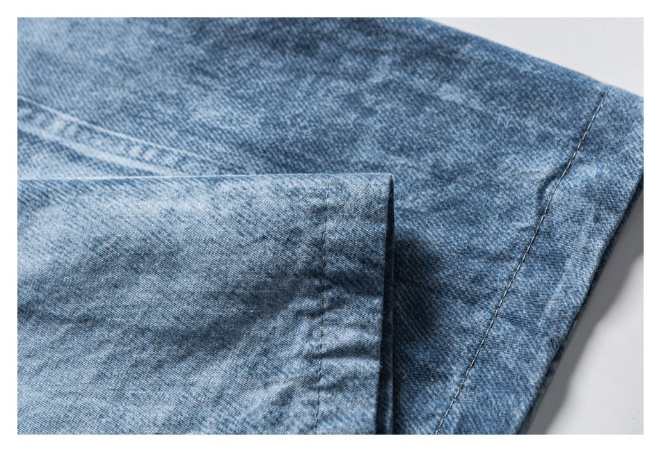 Close-up of overlapping blue washed shirt fabric with a stitched edge and seam.