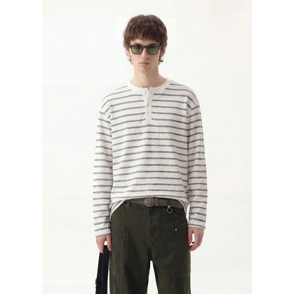 Front view of a model in a white and gray striped long-sleeve henley and dark olive cargo pants.