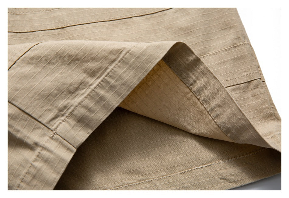 Close-up of a folded tan garment hem, showing the inner fabric and stitched seams.