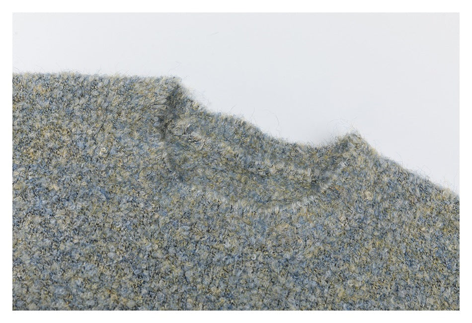 Close-up of the crew neckline and fuzzy marled knit texture of a blue-gray sweater.