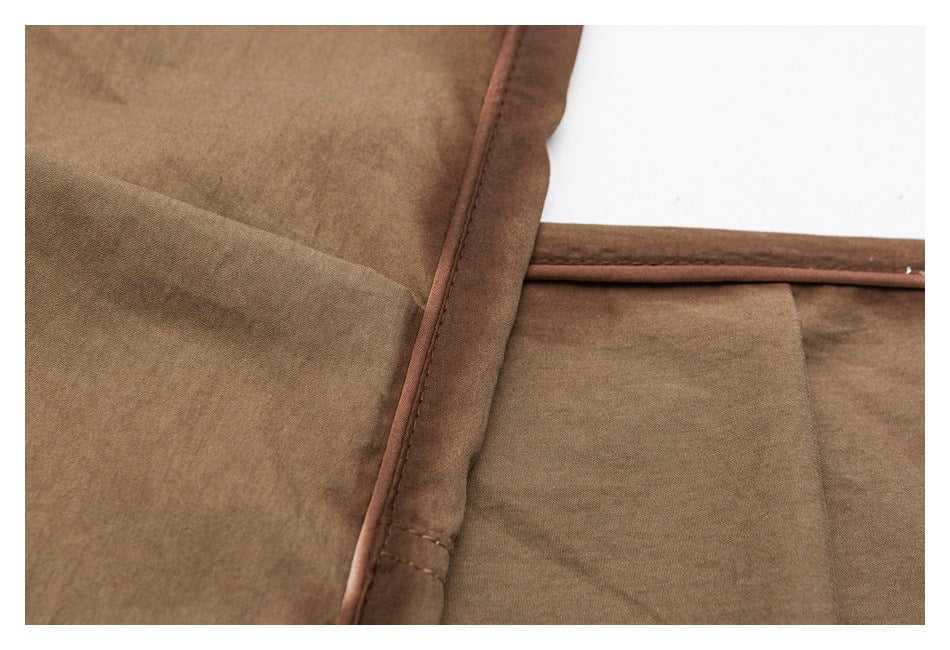 Close-up of tan pants fabric and stitched edge piping.