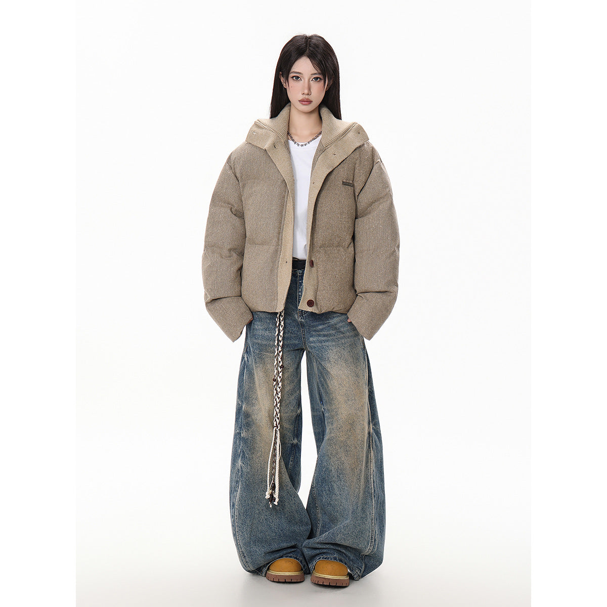 Model in a taupe padded jacket with a wide contrasting collar, worn with loose blue jeans.