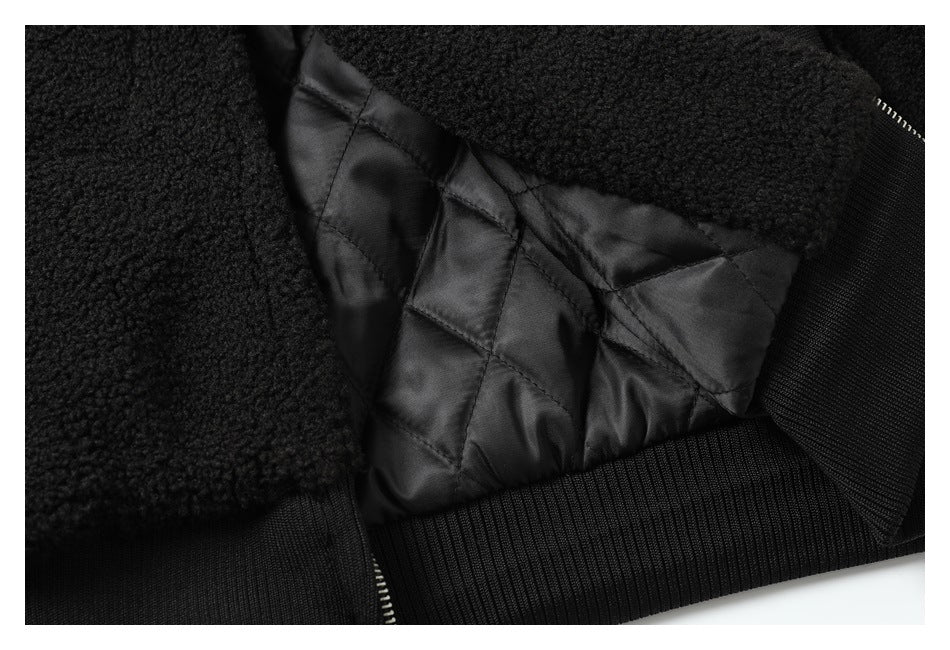 Close-up showing the jacket’s black quilted lining, textured outer fabric, ribbed trim and zipper teeth.
