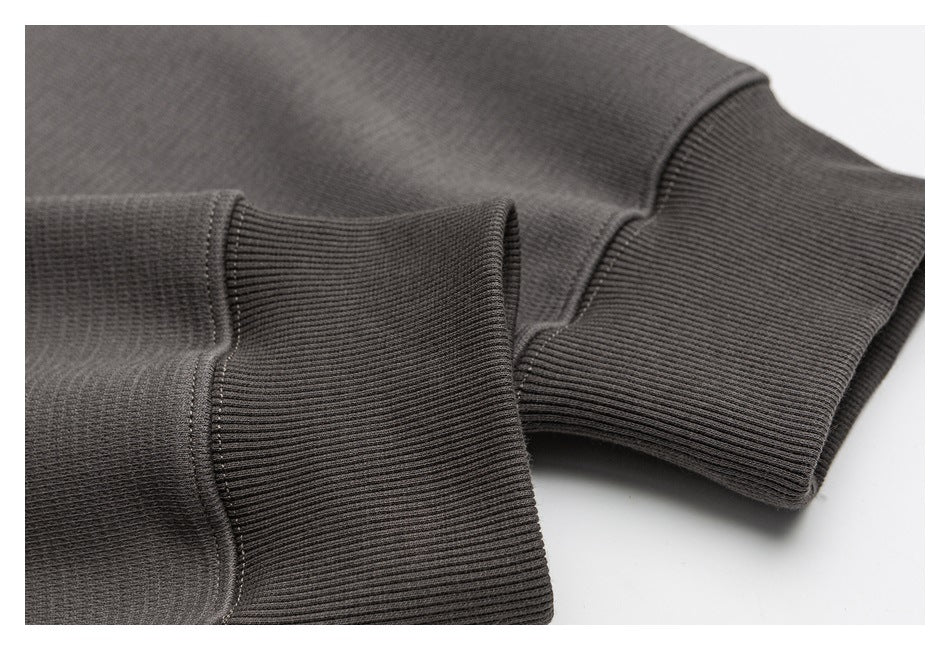 Close-up of ribbed cuffs on a charcoal garment.