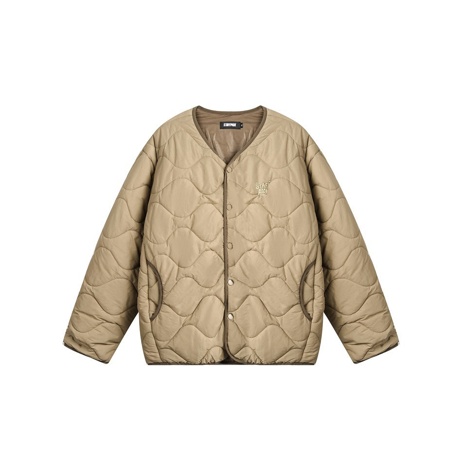 Front view of a beige quilted jacket with a V-neck, snap buttons, curved pockets, and small chest lettering.