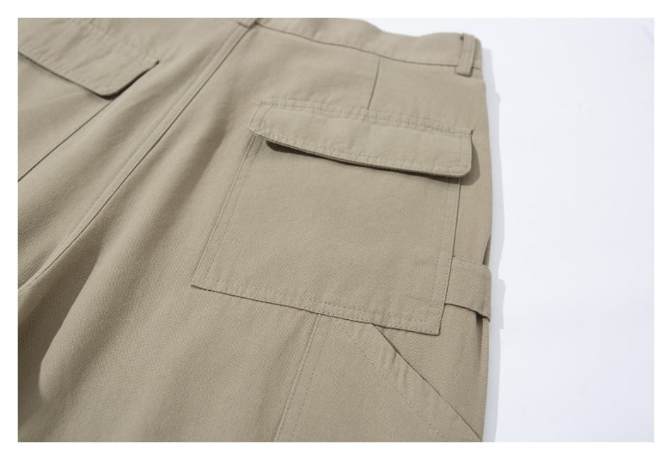 Close-up of beige trousers showing a large flap cargo pocket and belt loop.