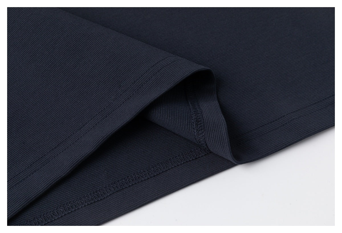 Close-up of the navy polo's folded hem and interior overlock stitching.