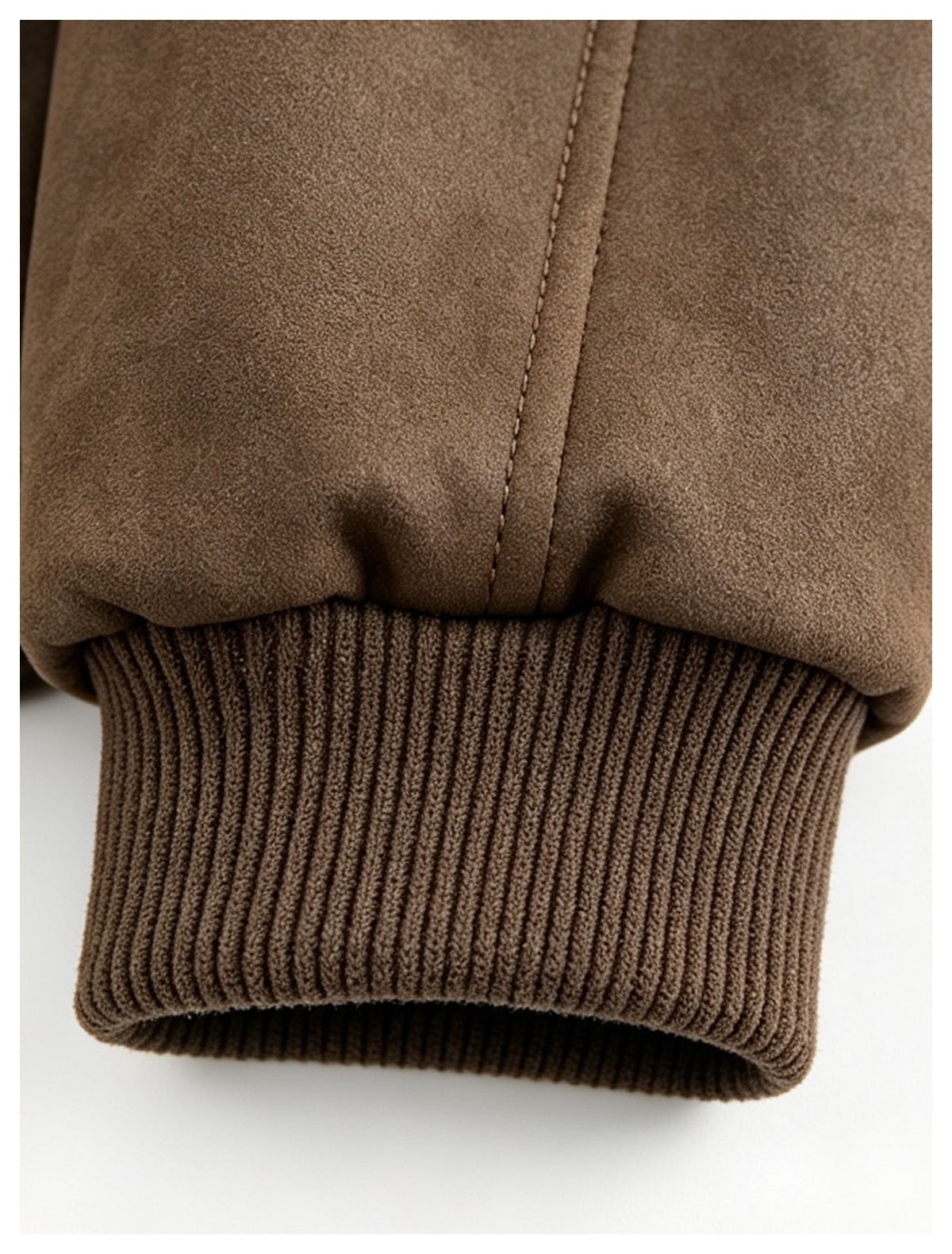Close-up of a brown jacket sleeve ending in a wide ribbed knit cuff.