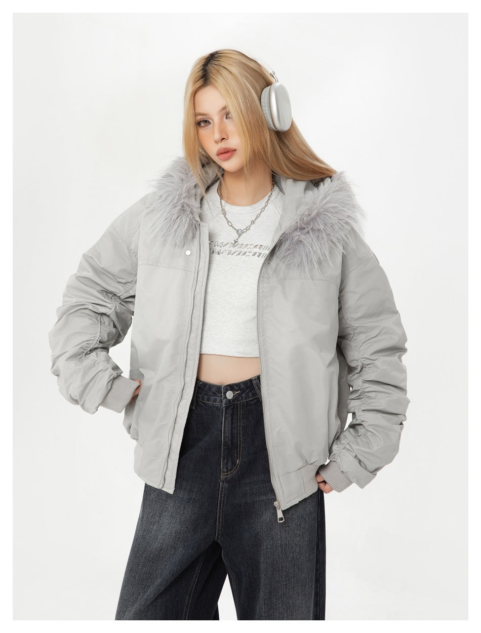Close view of a model in a light gray bomber jacket with fluffy faux-fur-textured hood trim and ruched sleeves