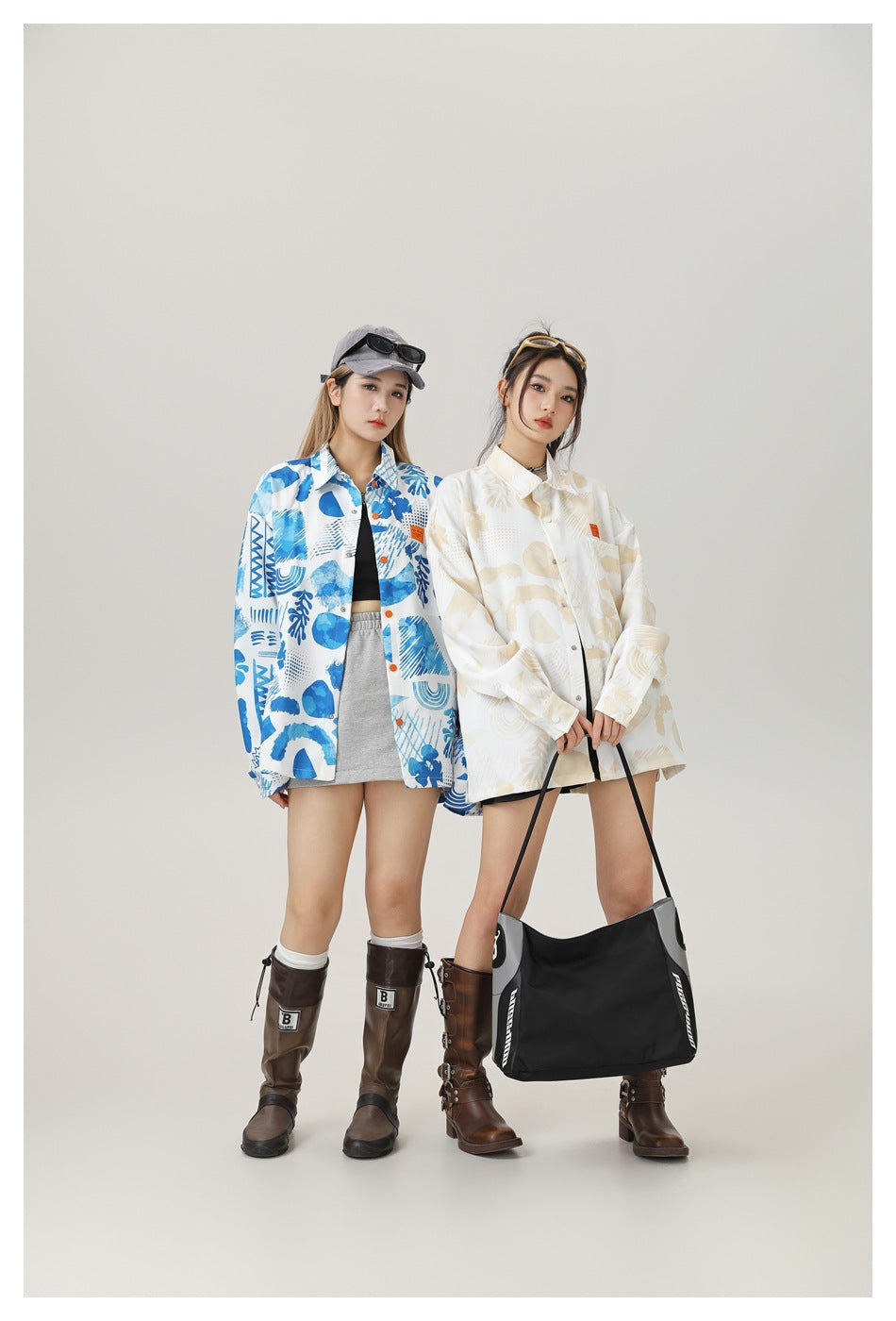 Two models wearing oversized abstract-print shirts in blue and white and cream and beige, shown from the front.