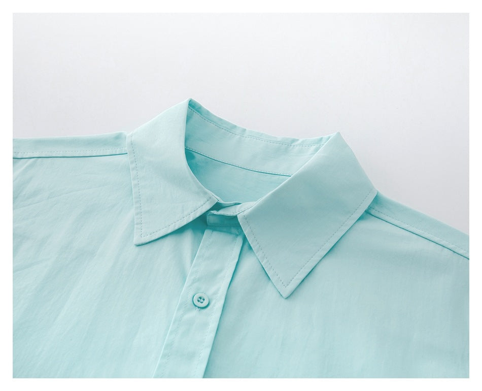 Close-up of the aqua shirt's pointed collar, shoulder seams, and top button on the front placket.
