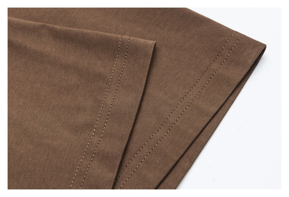 Close-up of a brown shirt hem with double-row stitching and a neatly finished edge.