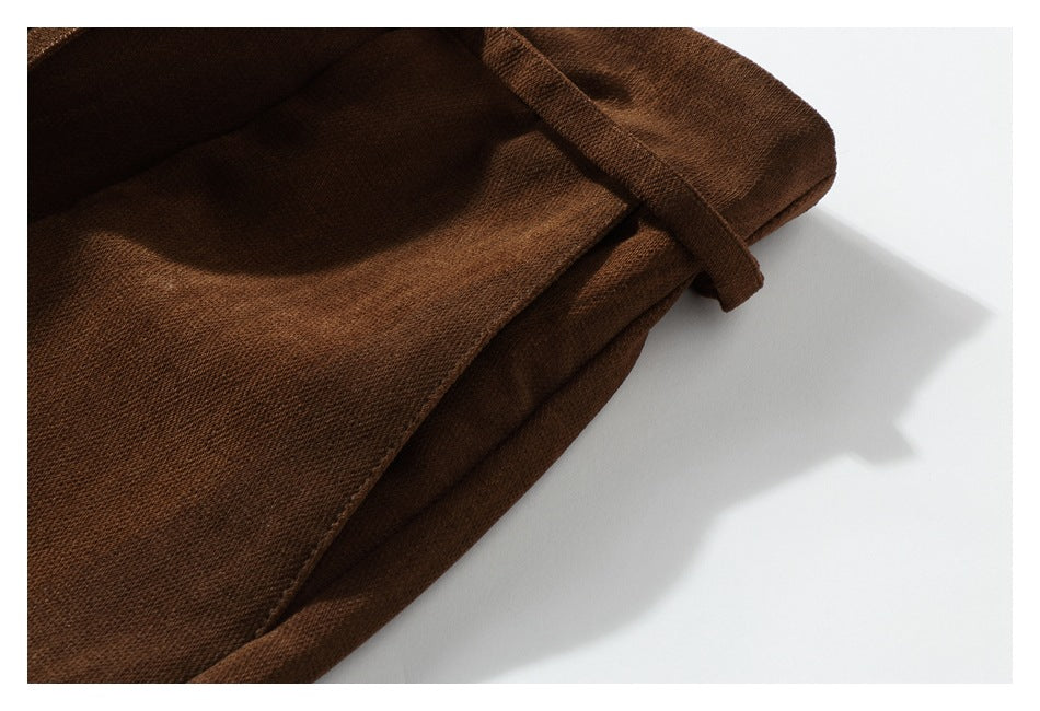 Close-up of dark brown garment fabric and a folded edge against a white background.