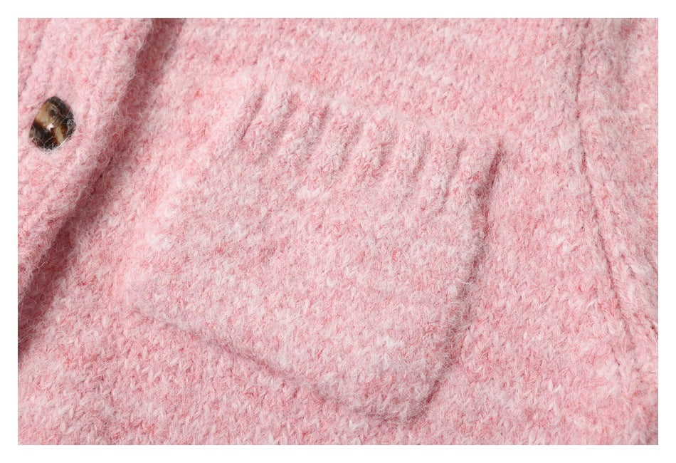 Close-up of the pink fuzzy knit fabric, a seam, and one dark button.