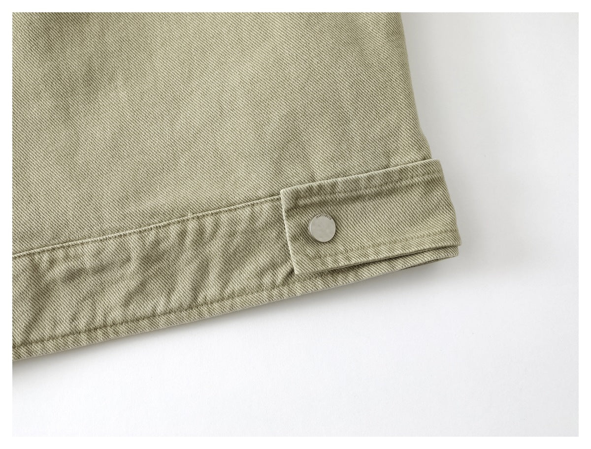 Close-up of the jacket's khaki hem with a snap-button adjustment tab and stitched seams.