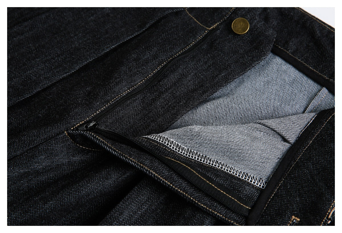 Close-up of unzipped black jeans showing the fly, brass button, and light-colored inner denim.