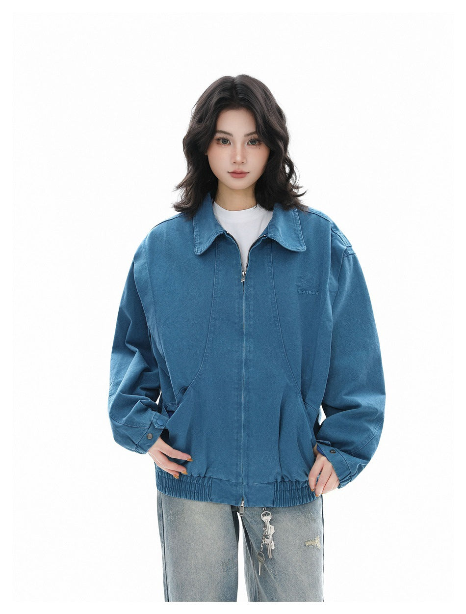 Front view of a model wearing a blue oversized zip-front jacket with a wide collar, large pockets and elastic hem.