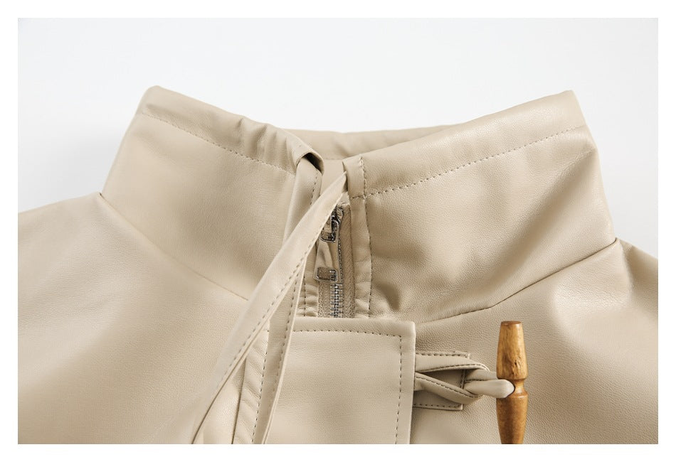 Close-up of a cream jacket’s stand collar, zipper, stitched placket, and wooden toggle closure.