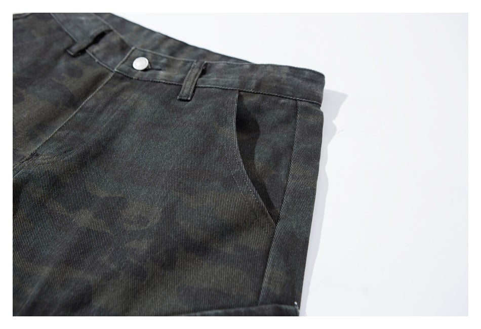 Close-up of the angled front pocket and waistband on dark charcoal camouflage pants.