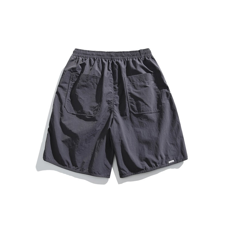 Back view of dark charcoal shorts with an elastic waistband and two large patch pockets.
