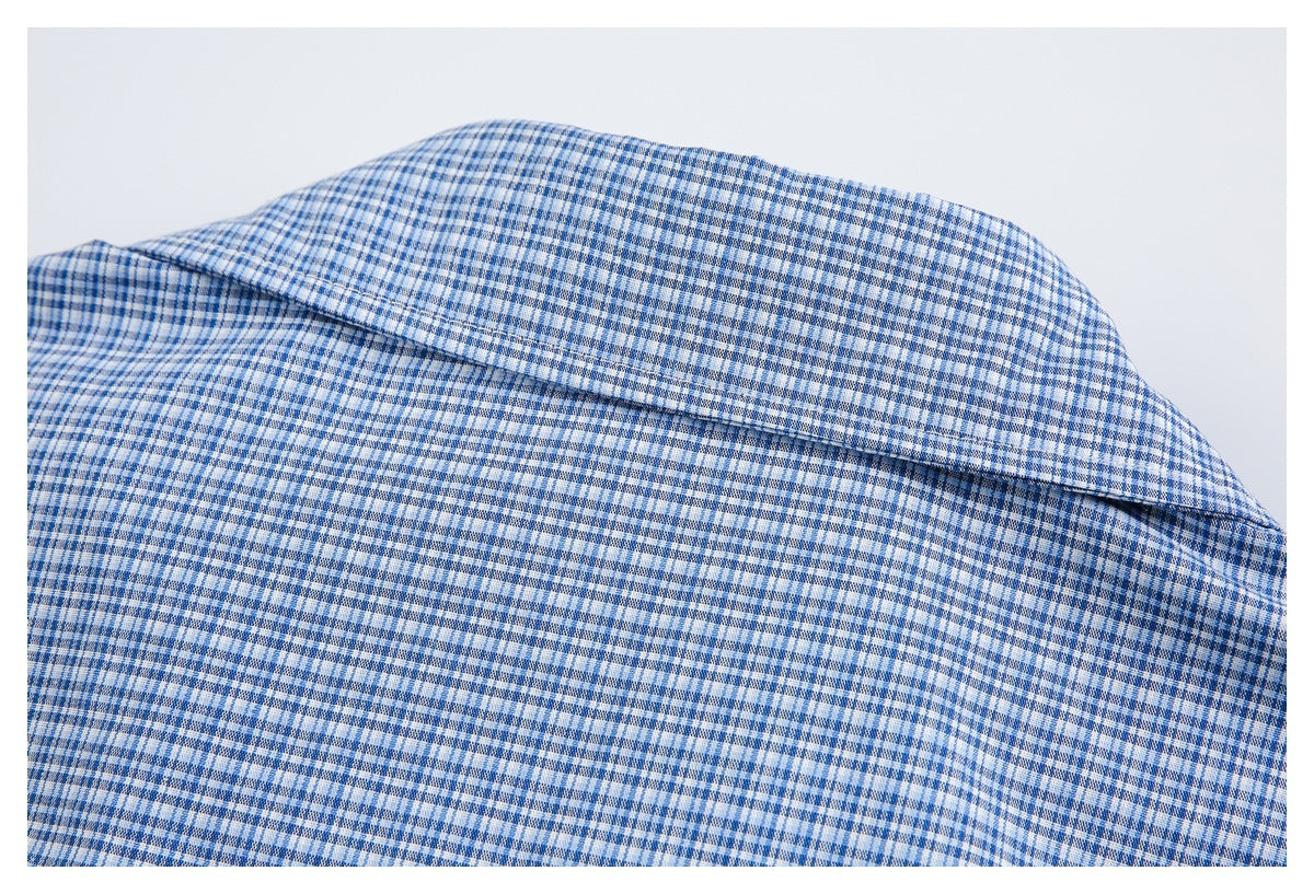 Close-up of a folded collar on a blue-and-white checked shirt.