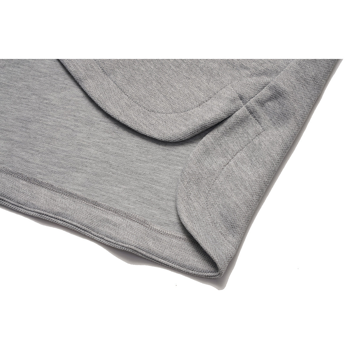 Close-up of the heather gray sweatshirt's curved hem and side seam.