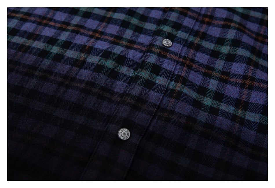 Close-up of a dark plaid shirt front placket with two round metal buttons.