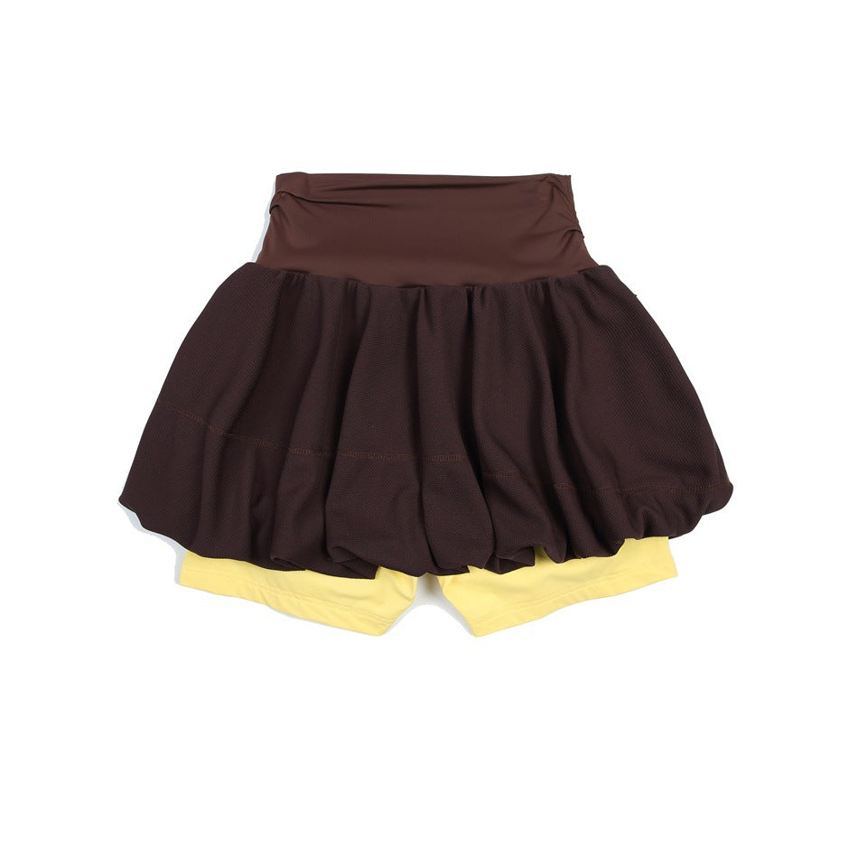 Flat lay of a dark brown bubble tennis skirt with a matching waistband and pale yellow built-in shorts.