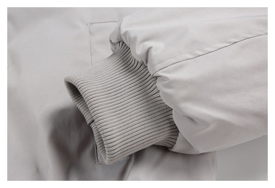 Close-up of a light gray jacket sleeve with a wide ribbed cuff and seam detail.